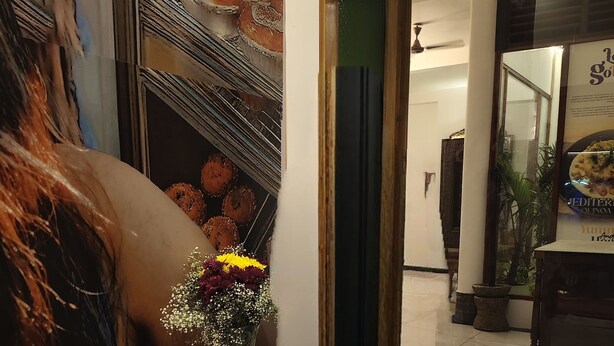 En hotellobby med ett marmorgolv, en receptionsdisk med en vas med blommor och en stor affisch på väggen.