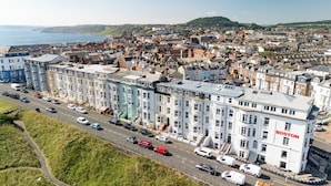 A multi-story building with a prominent 'BOSTON' sign, surrounded by a dense urban area with a coastal backdrop. - The Clarence Gardens Hotel, BW Signature Collection (Scarborough)