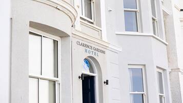 A building with a sign reading "Clarence Gardens Hotel".