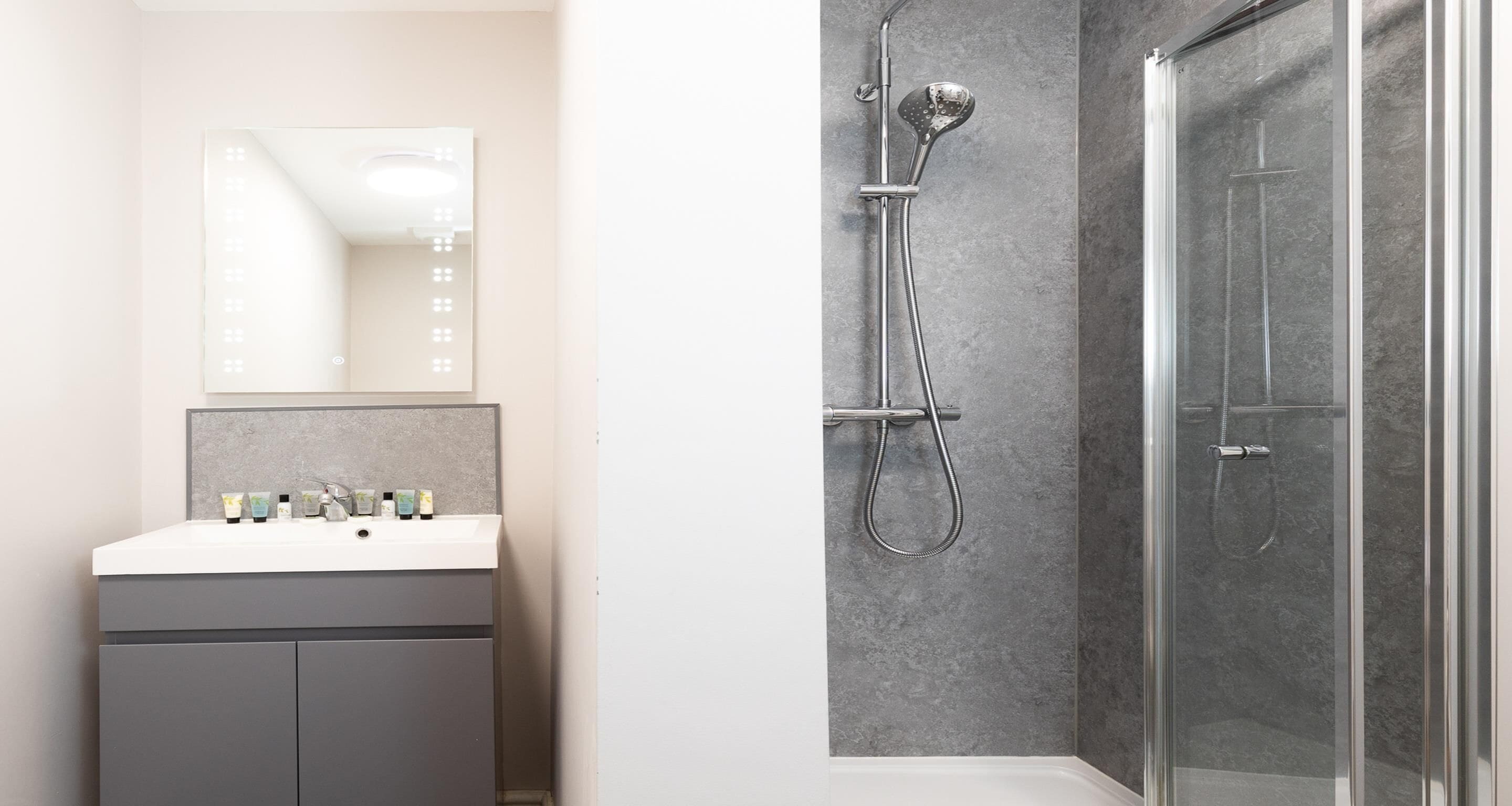 Une salle de bain moderne avec un meuble-lavabo, un miroir et une douche.