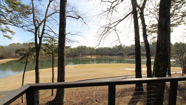 A view from a deck overlooking a lake with trees and a golf course. - Hot Springs Village Condo on the Green (Hot Springs)