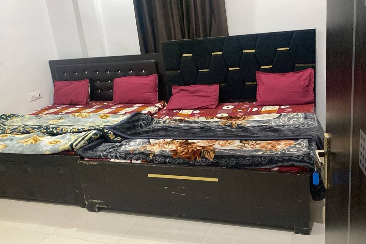 A bed with a black headboard, multiple pillows, and a patterned bedspread.