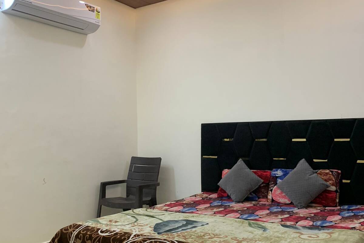 A bedroom with a bed, a ceiling fan, and an air conditioning unit.