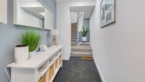 A hallway with a white console table, a mirror, a lamp, and a potted plant. - Darjeeling - North East Escapes (Alnwick)