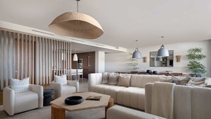Un soggiorno moderno con un divano componibile, un tavolino da caffè e illuminazione a sospensione.