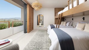 Una camera da letto moderna con un letto grande, una scala in legno, un'ampia finestra e vista sul deserto.