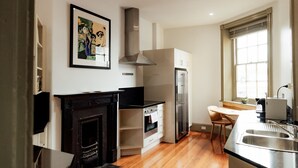 A modern kitchen with a fireplace, stainless steel appliances, and a window providing natural light.