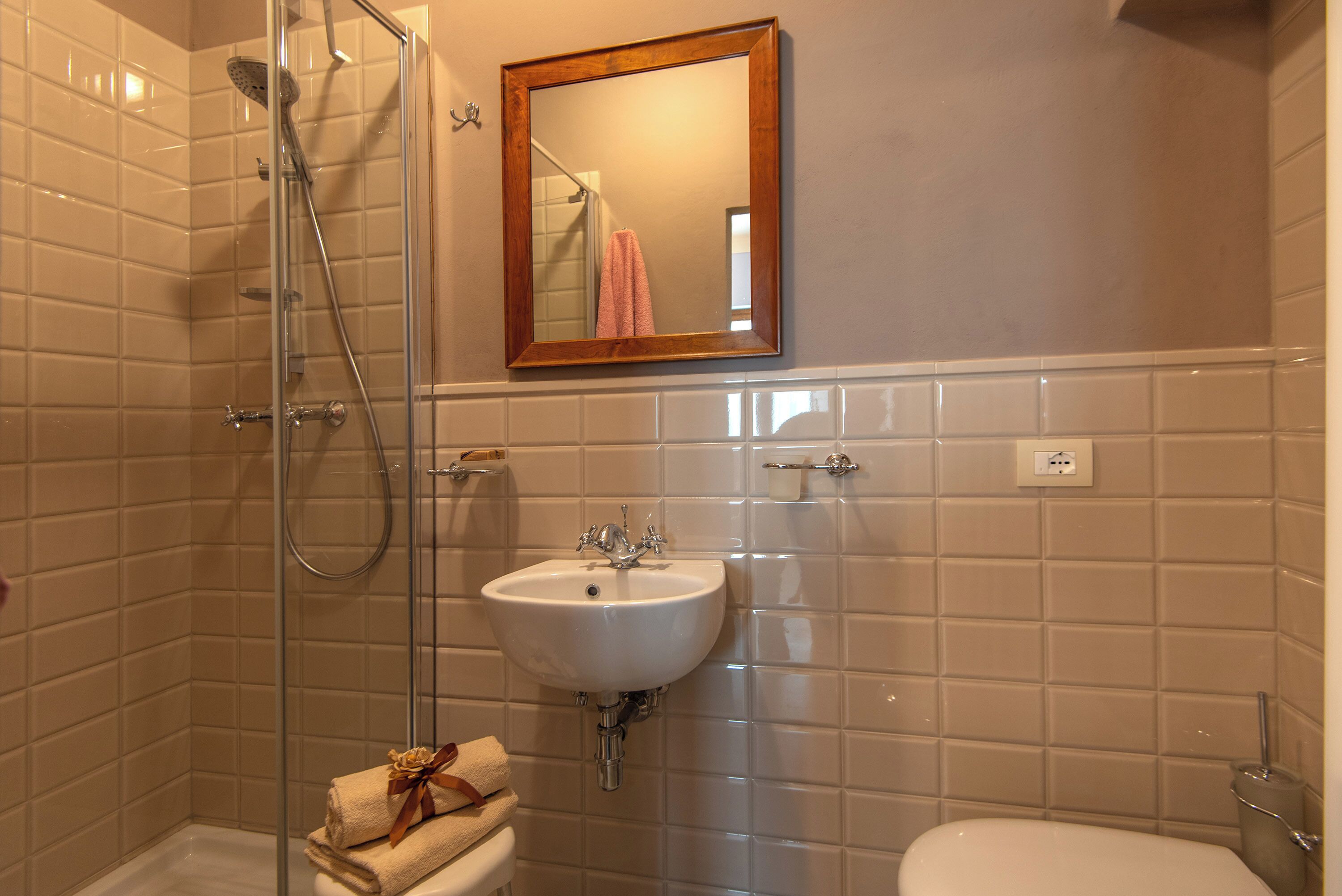 Une salle de bain avec une douche à parois de verre, un lavabo blanc et des toilettes.