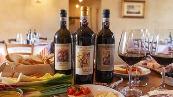 A table set with wine bottles, glasses, and a variety of food items.