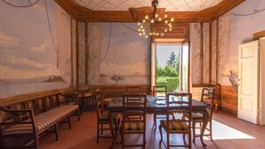 A dining area with wooden furniture, a chandelier, and a mural on the wall.
