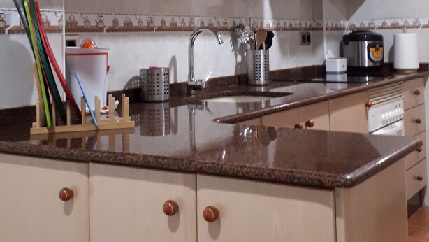 A kitchen with beige cabinets, a granite countertop, a stainless steel sink, and a stove. - Casa Pueblo Alzira (Alzira)