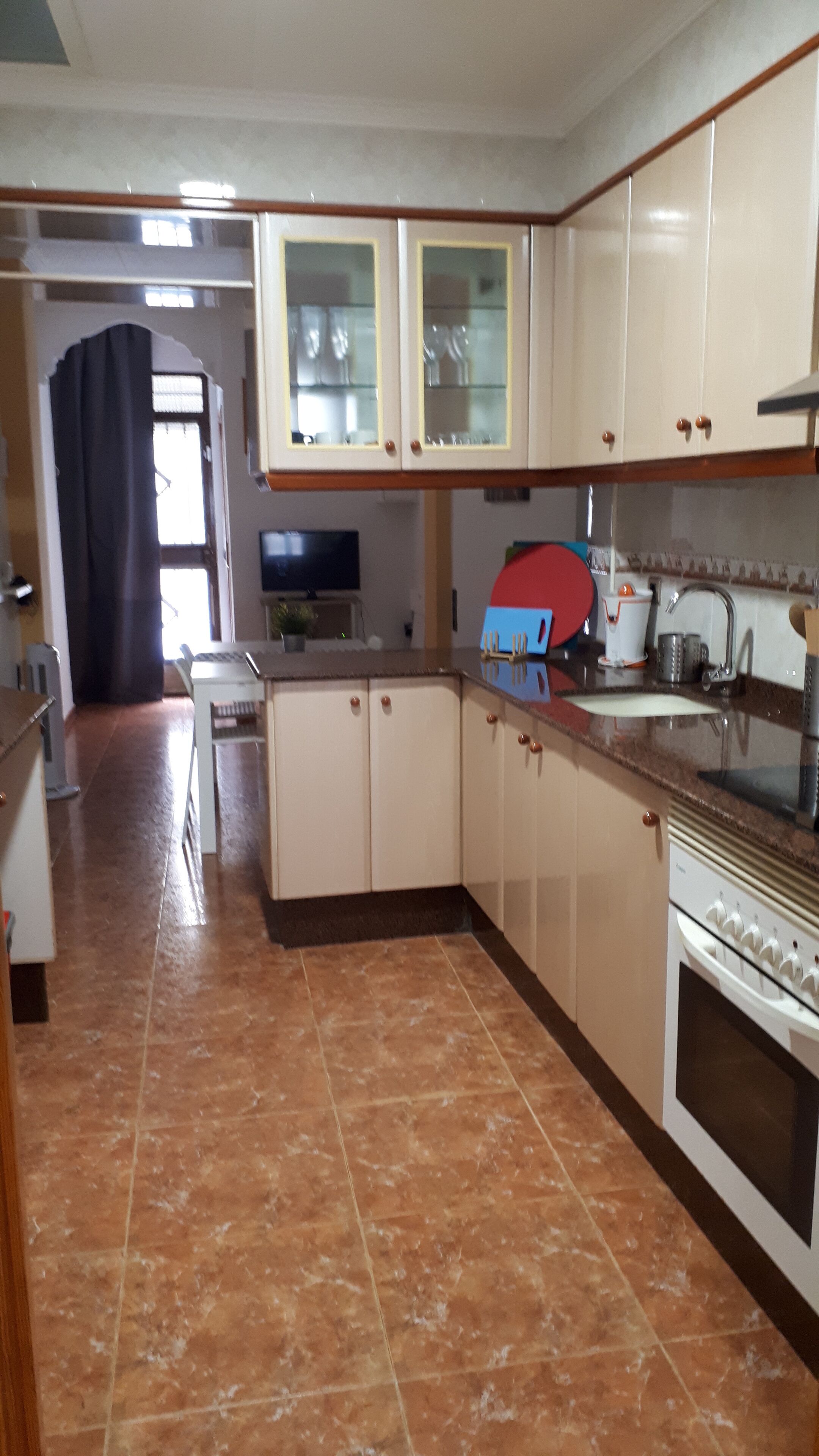 A kitchen with white cabinets, a tiled floor, and a stove.