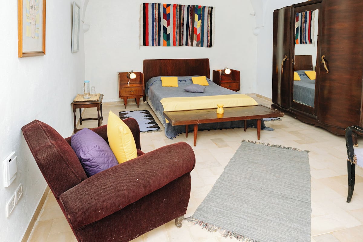 Une chambre à coucher avec un lit, un canapé, une armoire et un miroir.