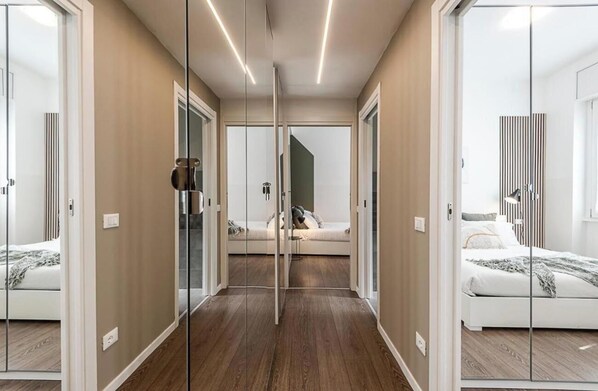 A modern bedroom with a glass partition, a sofa bed, and a bedside table.