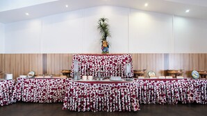 A buffet setup with a polka dot tablecloth, a central decorative plant, and various food items on display. - S V COMFORTS (Bengaluru)