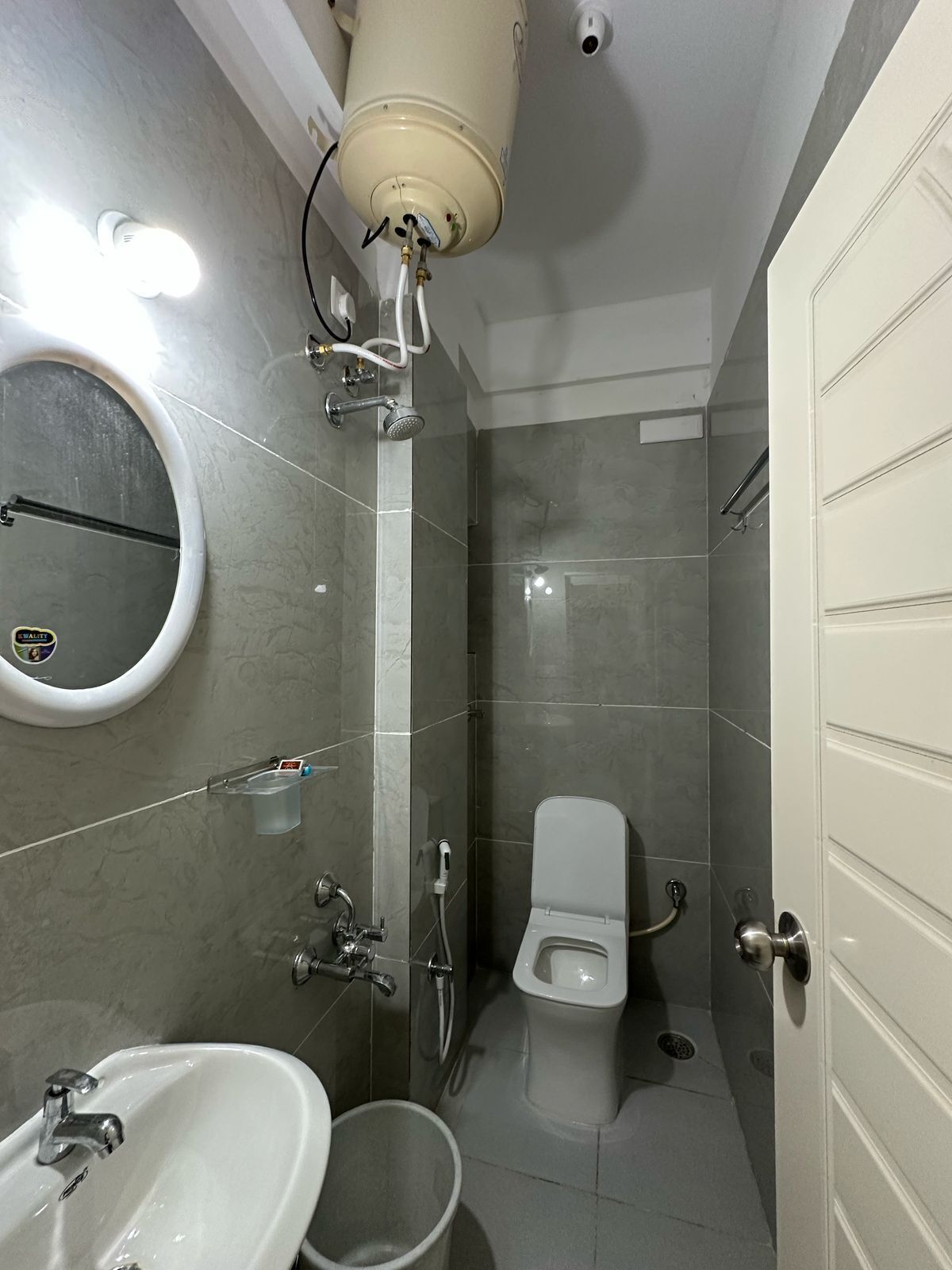 Une salle de bain moderne équipée de toilettes, d’un lavabo et d’une douche.
