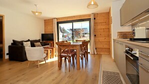 Ett modernt vardagsrum med en soffa, en tv och en matplats.