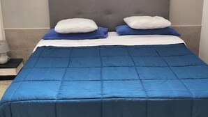 A bedroom with a bed, pillows, a painting on the wall, and a tiled floor. - Detached house with two entrances and parking space on private road, convenient and new (Gallipoli)