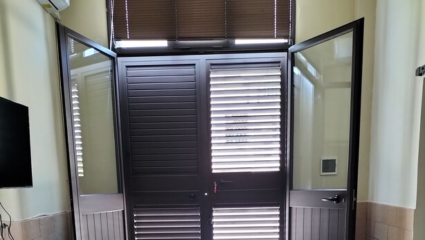 A dining area with a table, chairs, and a window with blinds. - Detached house with two entrances and parking space on private road, convenient and new (Gallipoli)