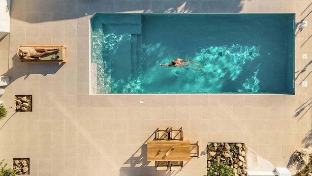 A rectangular swimming pool with clear water, surrounded by beige tiles. - Villa Froudi (Azogiras)