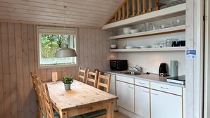 Una cocina compacta con gabinetes blancos, un microondas y una cafetera.