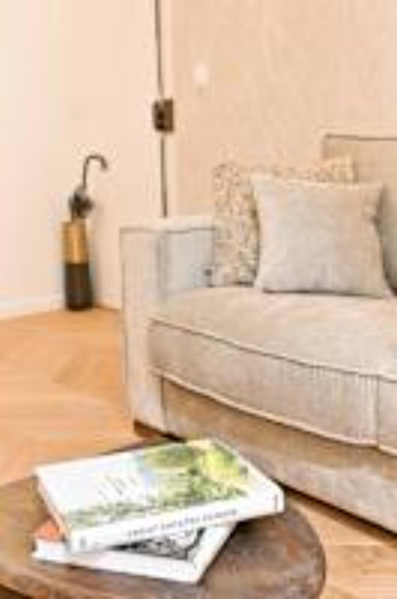A living room with a sofa, a coffee table with a magazine, and a lamp.