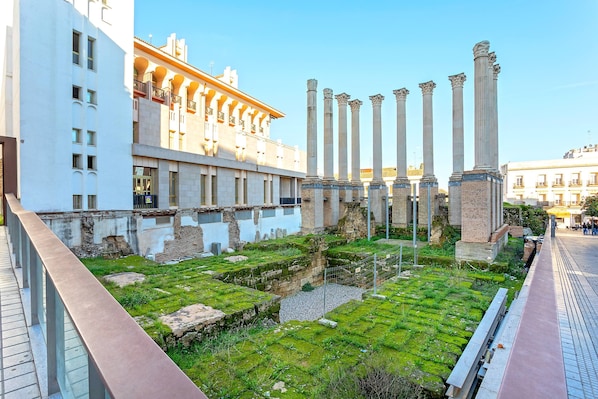 Un sitio histórico con columnas antiguas y un edificio moderno con balcones.