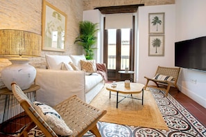 A living room with a sofa, two chairs, a TV, a lamp, a plant, and a patterned rug. - Genteel Home Santas Patronas (Seville)
