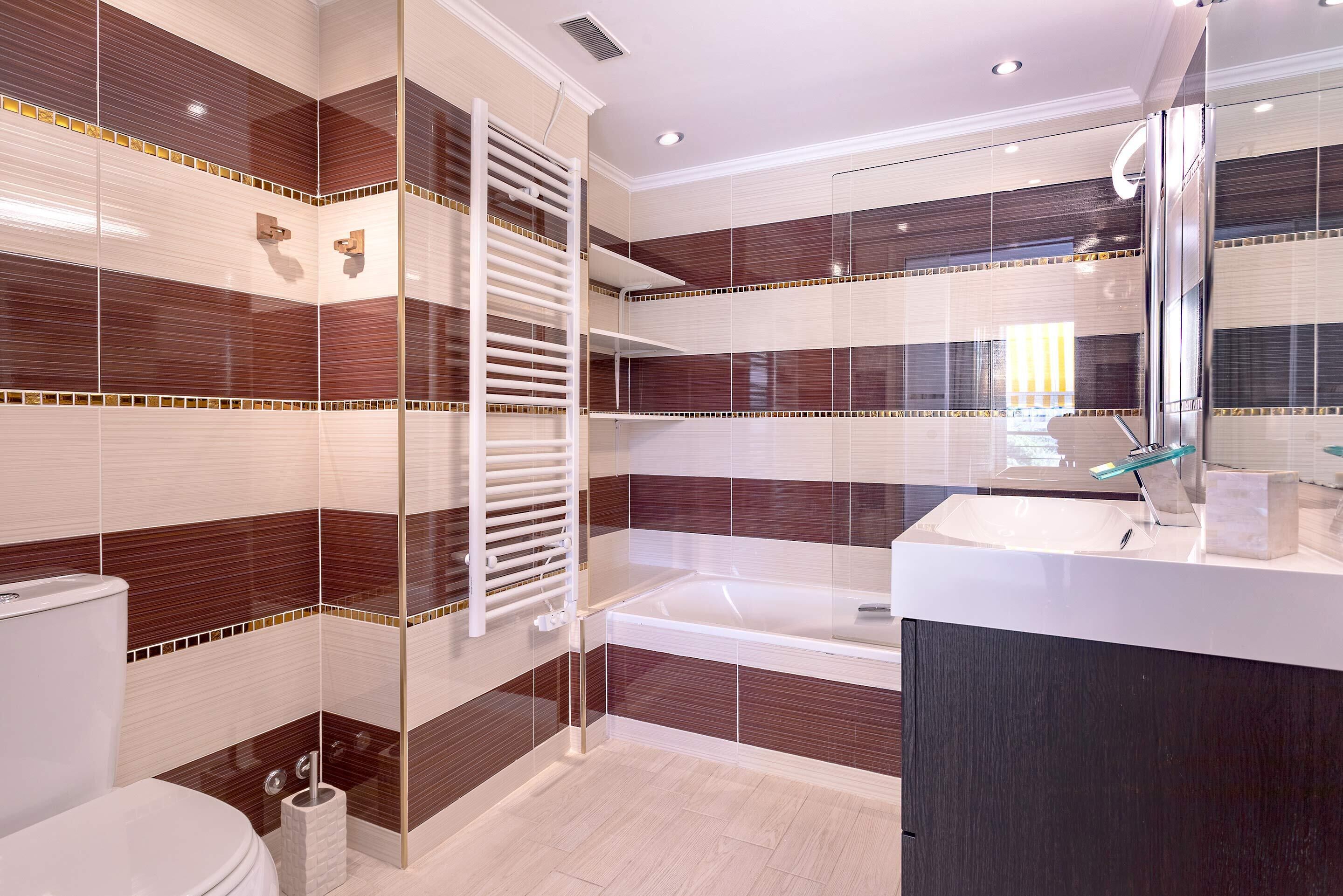 A modern bathroom with a bathtub, toilet, and vanity.