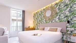 Una camera da letto moderna con un letto grande, un comodino, una parete decorativa e vista all'esterno.