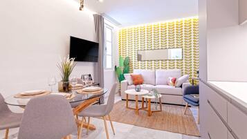 A modern living room with a sofa, coffee table, and dining area with chairs and a glass table.