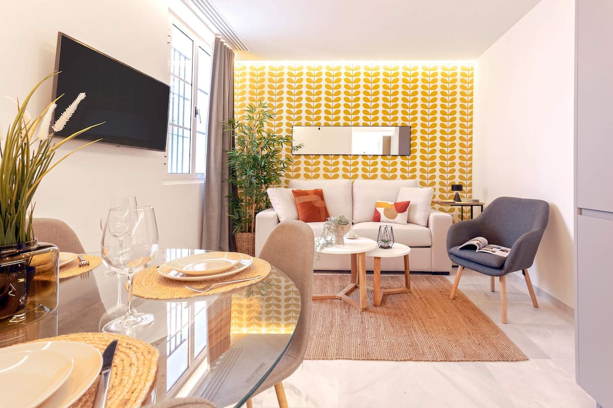 Un salon moderne avec un canapé, une table basse et un téléviseur fixé au mur.