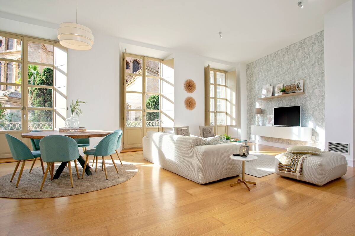 A modern living room with a sofa, chairs, a TV, and a fireplace.