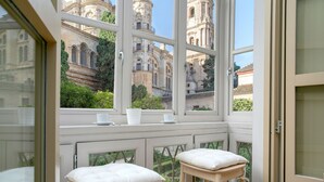 A room with a view of a historic building through large windows. - Genteel Home San Agustín (Málaga)
