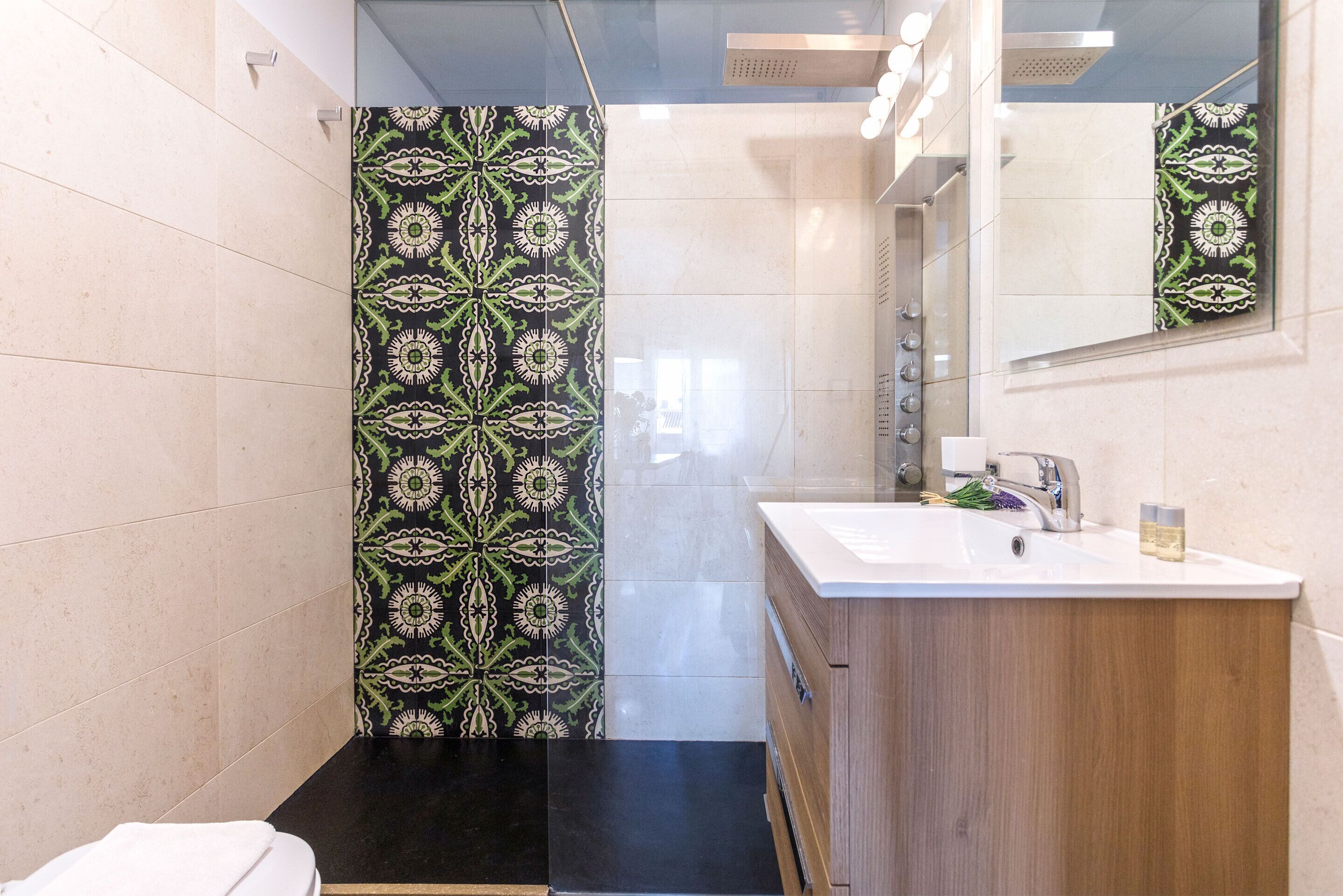 A modern bathroom with a shower, a sink, and a mirror.