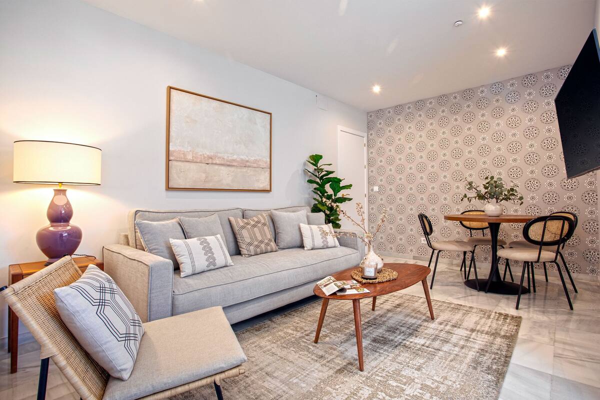Een moderne woonkamer met een bank, salontafel en eethoek.