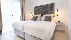 A double bed with a grey headboard and two bedside tables with wall-mounted lamps. - Genteel Home Ricardo Soriano Terrace (Marbella)