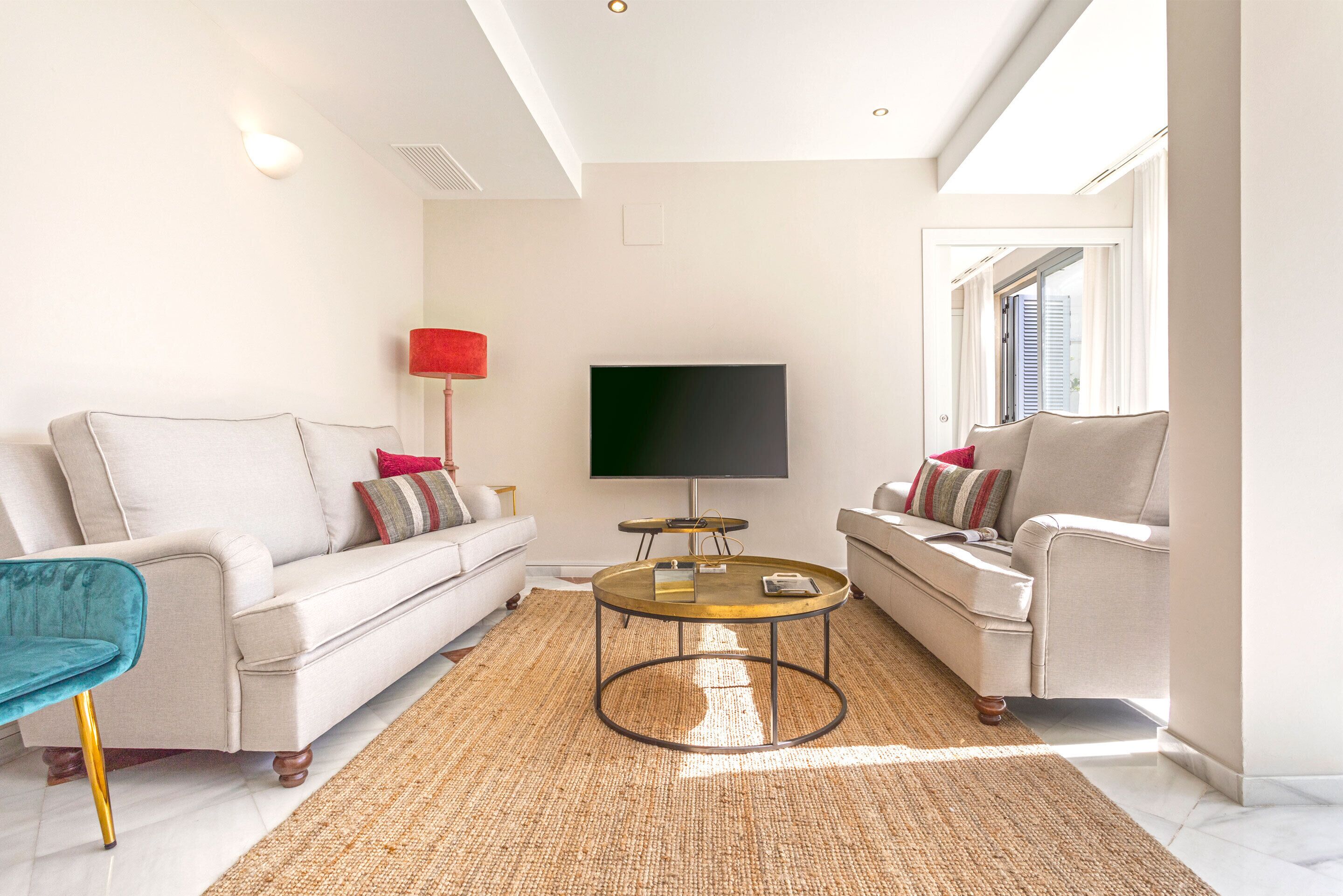 Uma sala de estar moderna com um sofá, uma mesa de centro e uma televisão.