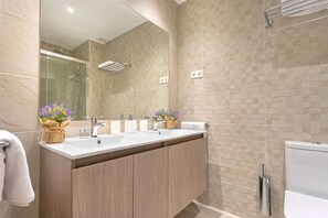 A modern bathroom with a double sink vanity, a glass shower enclosure, and a toilet. - Genteel Home María Zambrano (Málaga)