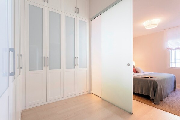 A bedroom with a bed, a wardrobe, and a sliding door.