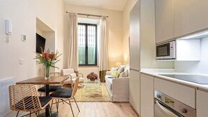 A compact living space with a dining area, sofa, and kitchenette. - Genteel Home Rodrigo Caro (Seville)