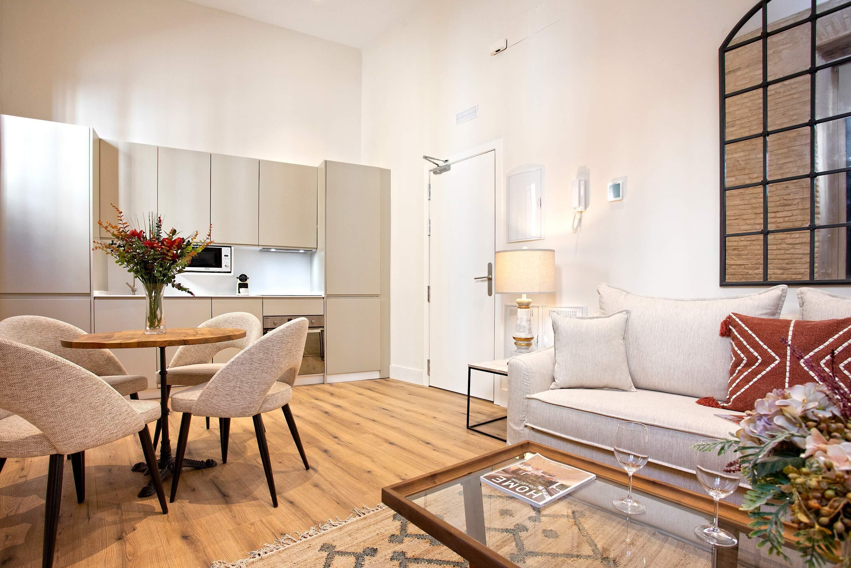 A modern living room with a sofa, coffee table, and dining area.
