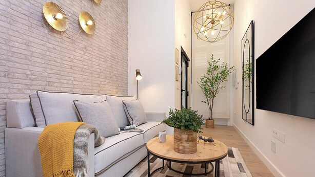 A modern living room with a grey sofa, a coffee table, and a potted plant. - Genteel Home La Paz (Granada)
