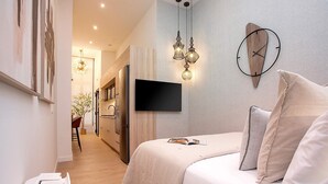 A modern bedroom with a bed, a mounted TV, and pendant lighting. - Genteel Home La Paz (Granada)