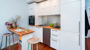 A modern kitchen with white cabinets, a wooden countertop, a built-in oven, and a sink. - Genteel Home Plaza Nueva (Seville)