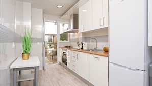 A modern kitchen with white cabinetry, a stainless steel range hood, and a built-in oven. - Genteel Home Santa Marta Córdoba (Córdoba)