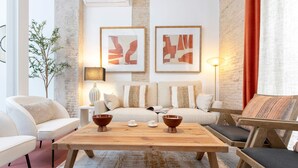 A modern living room with a wooden coffee table, two sofas, and a side table with a lamp. - Genteel Home Gran Poder (Seville)