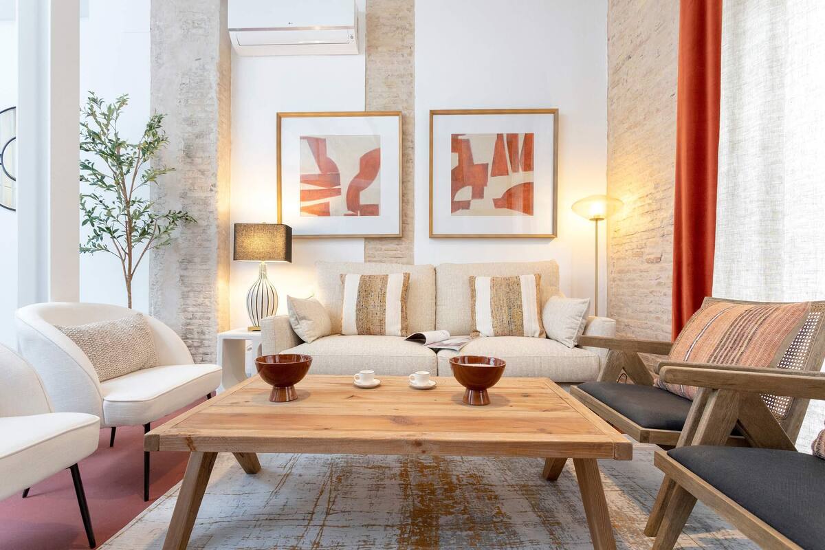 Un salon moderne avec une table basse en bois, deux canapés et une table d’appoint sur laquelle se trouve une lampe.