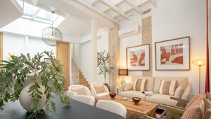 A modern living room with a sofa set, a dining table, and a large plant. - Genteel Home Gran Poder (Seville)
