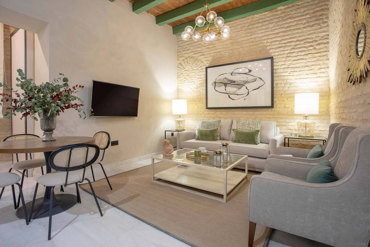 A modern living room with a round dining table, chairs, a sofa, and a coffee table.